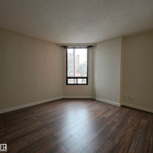 Unfurnished room featuring a textured ceiling and dark wood-type flooring - 2C 10050 118 Street, Edmonton, AB - Indoor Photo Showing Other Room