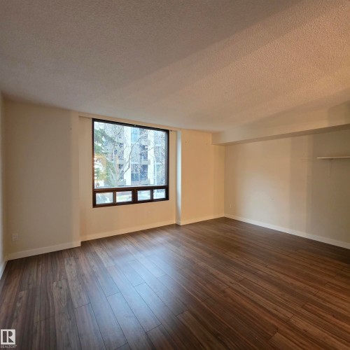 Unfurnished room with a textured ceiling and dark wood-style floors - 2C 10050 118 Street, Edmonton, AB - Indoor Photo Showing Other Room