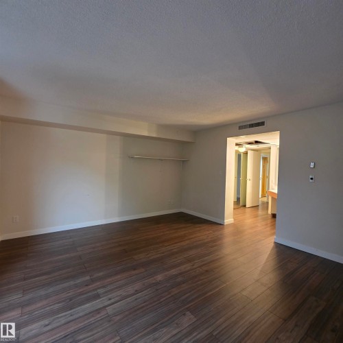 Unfurnished room featuring dark wood finished floors and a textured ceiling - 2C 10050 118 Street, Edmonton, AB - Indoor Photo Showing Other Room