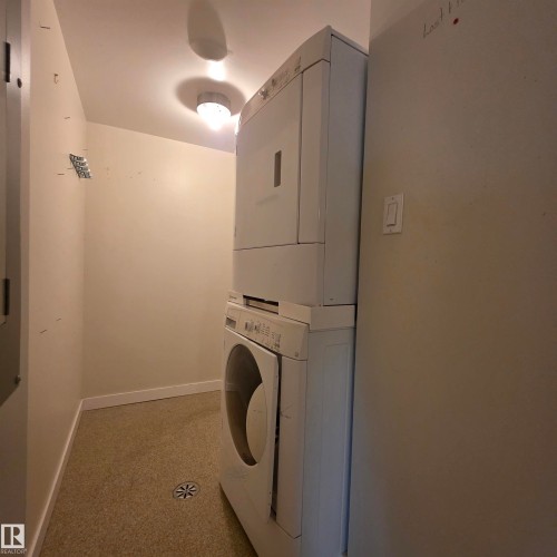 Laundry room featuring baseboards and stacked washer / dryer - 2C 10050 118 Street, Edmonton, AB - Indoor Photo Showing Laundry Room
