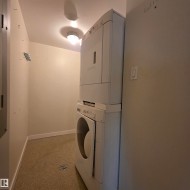 Laundry room featuring baseboards and stacked washer / dryer - 