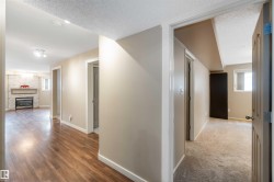 Hall featuring a textured ceiling and light wood-type flooring - 