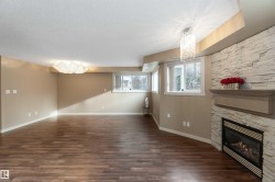 Unfurnished living room featuring a fireplace, hanging lights, dark wood-type flooring, and a textured ceiling - 
