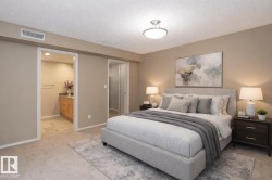 Bedroom featuring light colored carpet, a textured ceiling, and connected bathroom - 