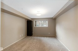 Unfurnished room featuring light carpet and a textured ceiling - 