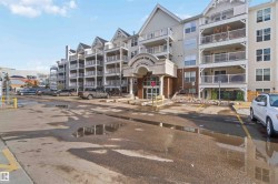 View of apartment building / complex featuring uncovered parking - 