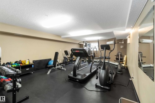 Exercise room with a textured ceiling - 113 10311 111 Street, Edmonton, AB - Indoor Photo Showing Gym Room