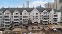 View of apartment building / complex with a city view and uncovered parking - 