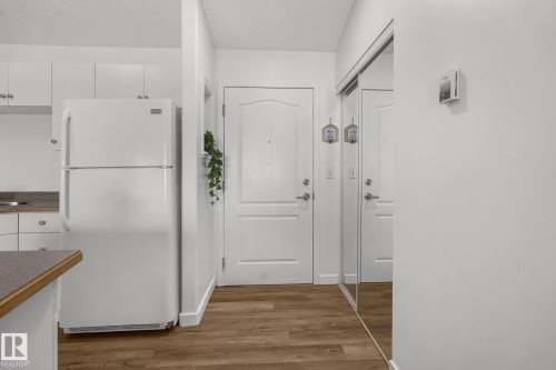 Corridor with dark wood-style floors and a textured ceiling - 502 7511 171 Street Nw, Edmonton, AB - Indoor