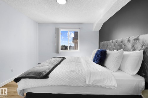 Bedroom with wood finished floors and a textured ceiling - 502 7511 171 Street Nw, Edmonton, AB - Indoor Photo Showing Bedroom