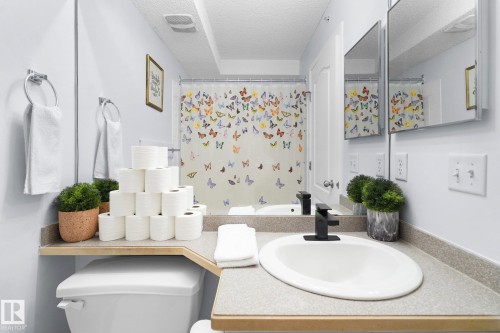 Full bathroom with vanity, a shower with shower curtain, and a textured ceiling - 502 7511 171 Street Nw, Edmonton, AB - Indoor Photo Showing Bathroom