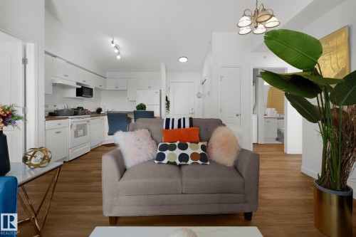 Living room featuring vaulted ceiling, dark wood-style flooring, and a chandelier - 502 7511 171 Street Nw, Edmonton, AB - Indoor Photo Showing Living Room