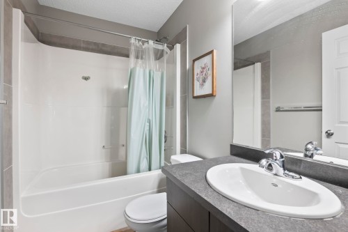 Bathroom with shower / bathtub combination with curtain, vanity, and a textured ceiling - 3221 Cherry Cres Sw, Edmonton, AB - Indoor Photo Showing Bathroom