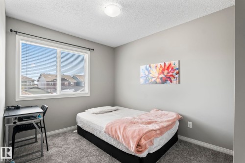 Carpeted bedroom featuring a textured ceiling and baseboards - 3221 Cherry Cres Sw, Edmonton, AB - Indoor Photo Showing Bedroom