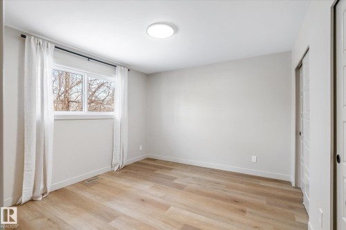 Unfurnished bedroom with light wood-type flooring and two closets - 4120 108 Street, Edmonton, AB - Indoor Photo Showing Other Room