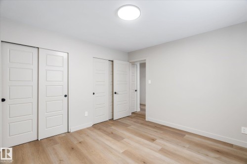 Unfurnished bedroom featuring multiple closets and light wood-style floors - 4120 108 Street, Edmonton, AB - Indoor Photo Showing Other Room