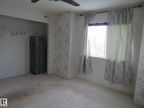 Unfurnished bedroom featuring a ceiling fan, a closet, and a textured ceiling - 2945 26 Street, Edmonton, AB - Indoor