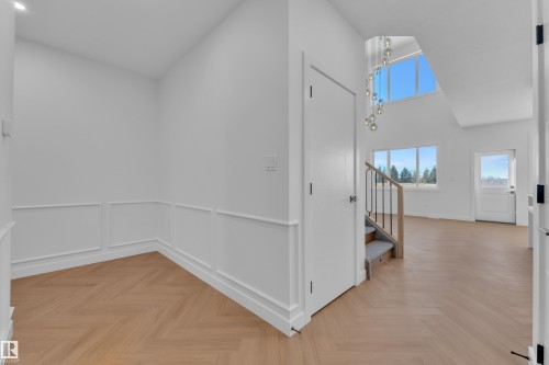 Hallway with a high ceiling, parquet flooring, wainscoting, and suspended lighting - 38 Grayson Green, Stony Plain, AB - Indoor Photo Showing Other Room