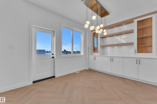 Unfurnished dining area featuring suspended lighting and parquet flooring - 38 Grayson Green, Stony Plain, AB - Indoor Photo Showing Other Room