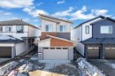 Contemporary house featuring an attached garage, stone siding, driveway, and board and batten siding - 38 Grayson Green, Stony Plain, AB  - Outdoor 