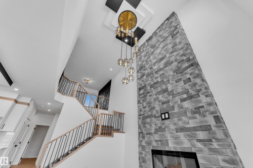 Stairs featuring a glass covered fireplace, a high ceiling, and recessed lighting - 38 Grayson Green, Stony Plain, AB - Indoor Photo Showing Other Room