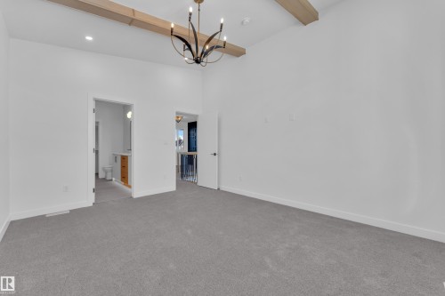 Spare room with light colored carpet and suspended lighting - 38 Grayson Green, Stony Plain, AB - Indoor Photo Showing Other Room