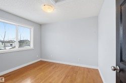 Empty room featuring light wood-type flooring and a textured ceiling - 