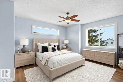 Bedroom featuring dark wood finished floors, a ceiling fan, multiple windows, and a textured ceiling - 2953 26 Street, Edmonton, AB - Indoor Photo Showing Bedroom
