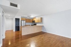 Kitchen featuring light countertops, light wood-type flooring, a peninsula, stainless steel appliances, and a textured ceiling - 