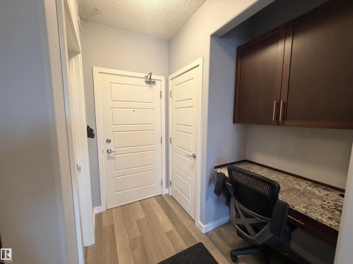 Office with built in desk, a textured ceiling, and light wood-style floors - 417 1004 Rosenthal Boulevard, Edmonton, AB - Indoor Photo Showing Office