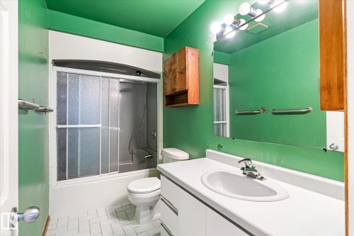 Bathroom featuring vanity, shower / bath combination with glass door, and light tile patterned floors - 12232 135 Street, Edmonton, AB - Indoor Photo Showing Bathroom