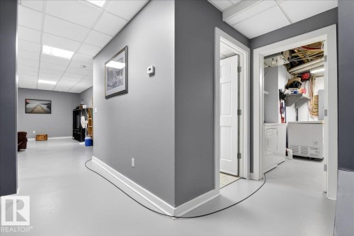 Hall featuring concrete floors, a drop ceiling, and washer / clothes dryer - 5019 48 Avenue, Chipman, AB - Indoor Photo Showing Other Room