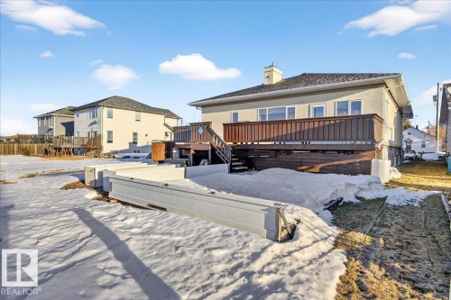 Snow covered rear of property with a deck, a residential view, and a chimney - 5019 48 Avenue, Chipman, AB - Outdoor With Deck Patio Veranda