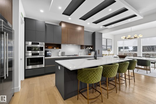 Kitchen with a kitchen breakfast bar, modern cabinets, stainless steel appliances, a spacious island, and light wood-style flooring - 1132 Wahl Place, Edmonton, AB - Indoor Photo Showing Kitchen With Upgraded Kitchen