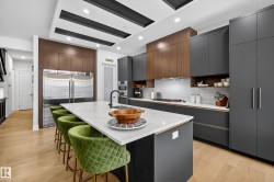 Kitchen with a kitchen bar, modern cabinets, a kitchen island with sink, stainless steel appliances, and recessed lighting - 