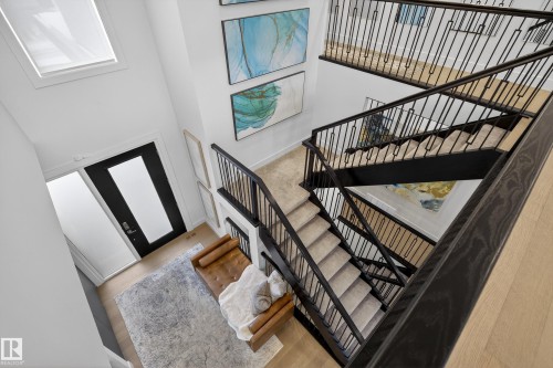 Stairs with a high ceiling and wood finished floors - 1132 Wahl Place, Edmonton, AB - Indoor Photo Showing Other Room