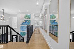 Corridor featuring an upstairs landing, a chandelier, and wood finished floors - 