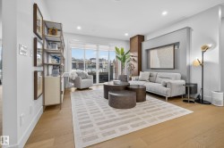 Living area with light wood-type flooring and recessed lighting - 