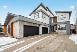Contemporary home with stucco siding, brick siding, stone siding, and driveway - 