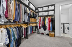 Walk in closet with independent washer and dryer and light carpet - 
