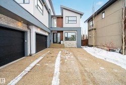 View of front of home with stucco siding, a garage, brick siding, and driveway - 