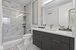 Full bathroom with vanity, a marble finish shower, and light marble finish floors - 