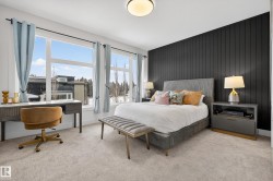 Carpeted bedroom with an accent wall, wood walls, and an office area - 