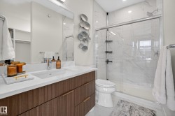 Bathroom with vanity, a marble finish shower, and light marble finish flooring - 