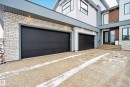 View of property exterior with stucco siding, a garage, driveway, and brick siding - 1132 Wahl Place, Edmonton, AB  - Outdoor 