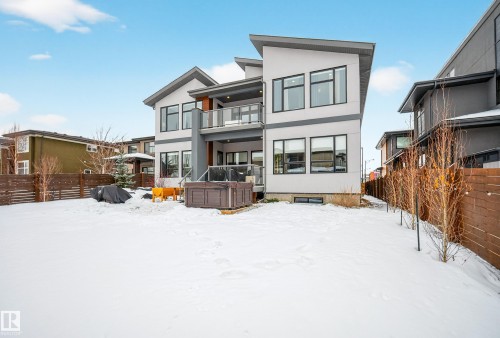 Snow covered house with a fenced backyard, stucco siding, a balcony, and a hot tub - 1132 Wahl Place, Edmonton, AB - Outdoor