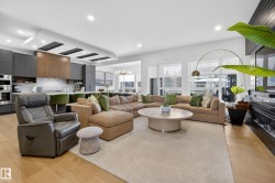 Living room with light wood-style floors and suspended lighting - 