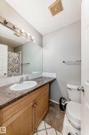 Full bath featuring vanity, a shower with shower curtain, and light tile patterned flooring - 