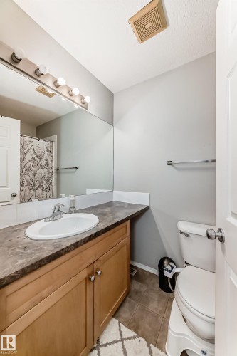 Full bath featuring vanity, a shower with shower curtain, and light tile patterned flooring - 185 230 Edwards Drive, Edmonton, AB - Indoor Photo Showing Bathroom