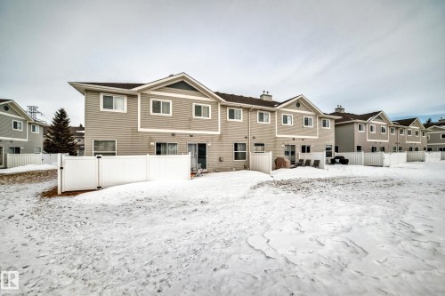 Snow covered property featuring a chimney and a residential view - 185 230 Edwards Drive, Edmonton, AB - Outdoor
